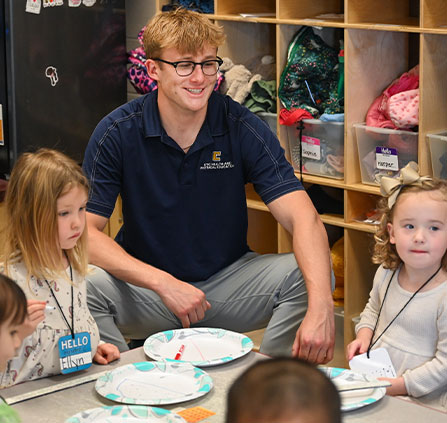 Photo of a teacher and young students. Link to Tangible Personal Property.